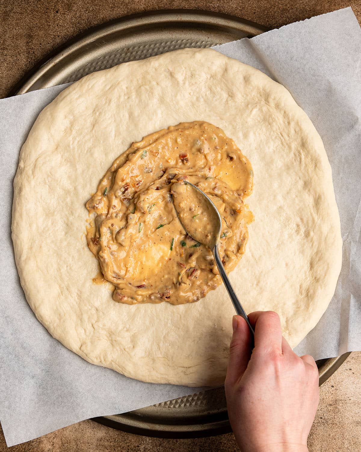 spread sauce on pizza dough