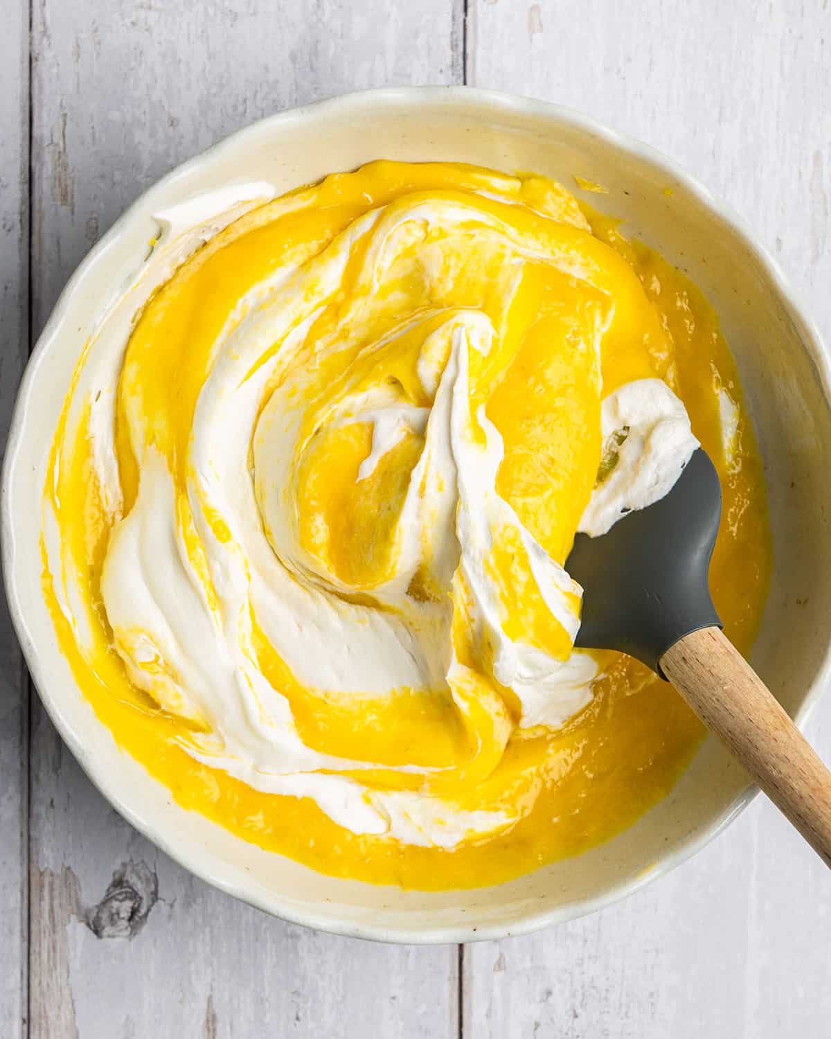 fold whipped cream into mango curd